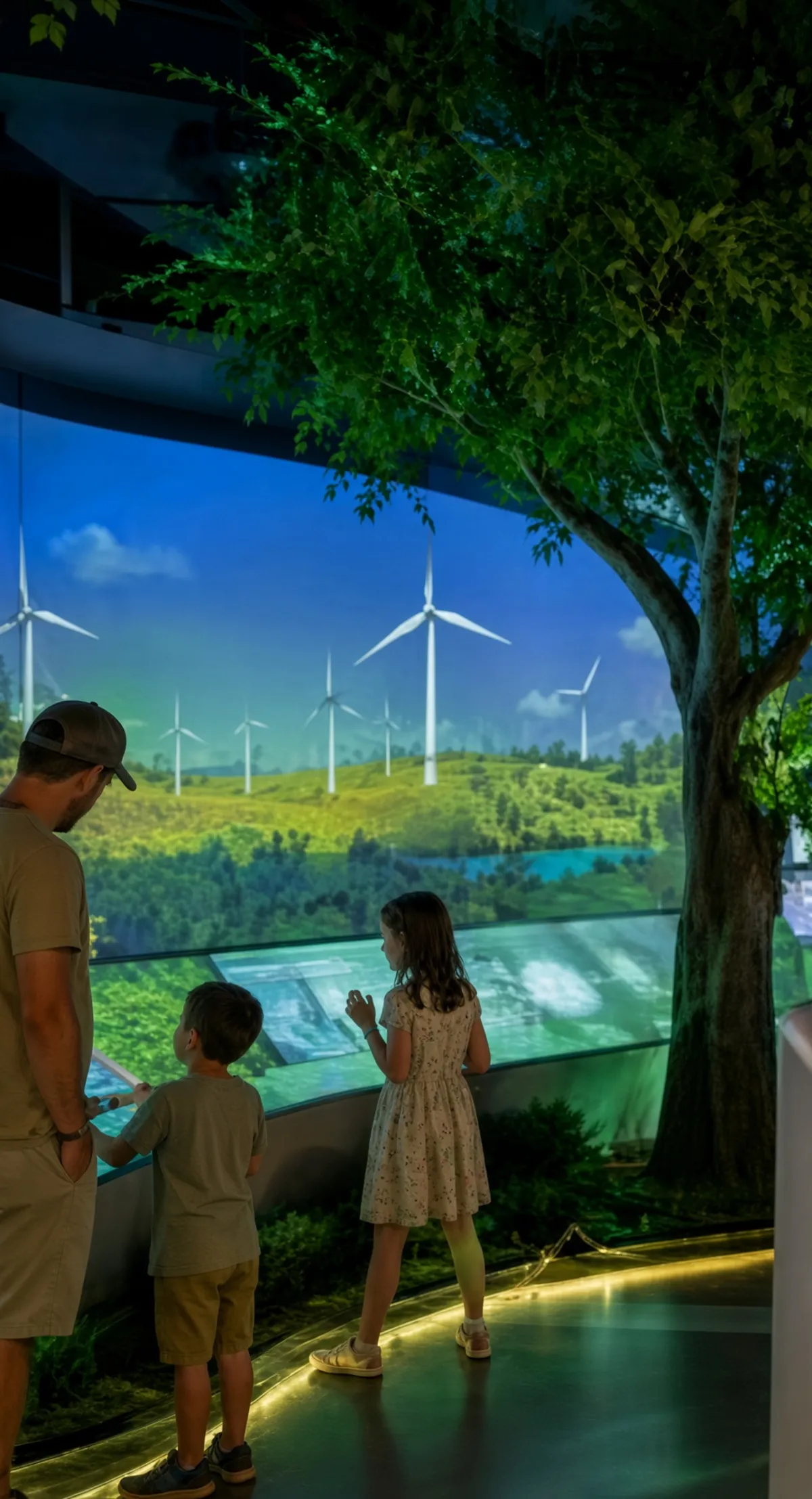 Conceptual rendering of a father and two children at an exhibit with a large curved screen showing wind turbines and an artificial tree